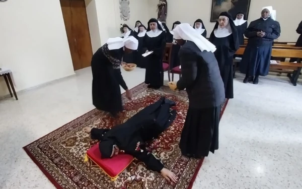 Sor Marí Zhang se postra en tierra en señal de humildad, durante el rito de sus votos perpetuos. Crédito: Diócesis de Salamanca.